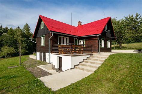Fasáda s červenou střechou a páskami
